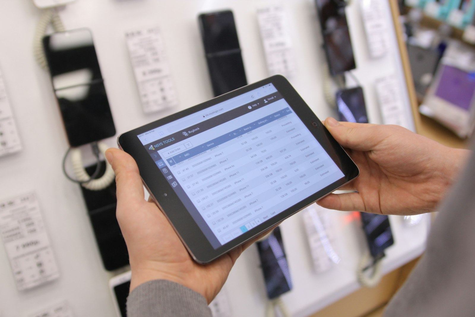 Hands holding a tablet showing a digital operations dashboard