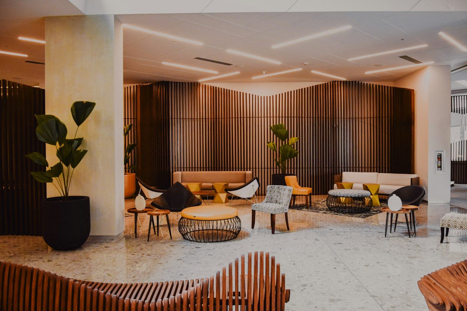 An upscale hotel lobby with lounge seating and greenery