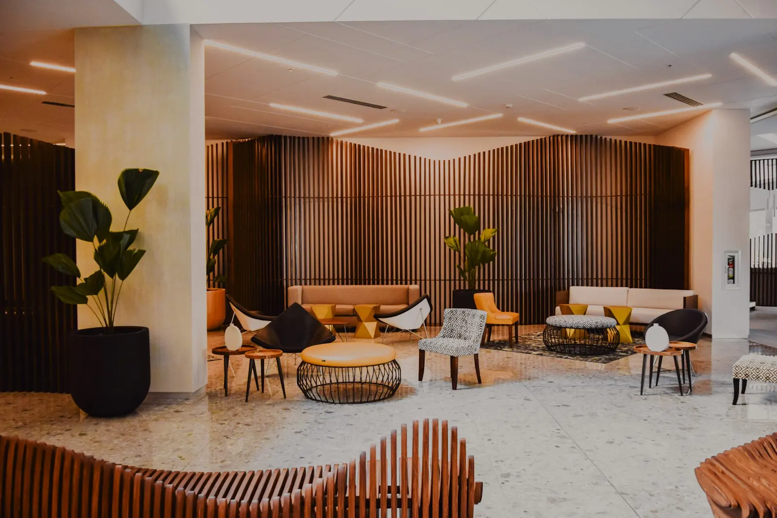An upscale hotel lobby with lounge seating and greenery